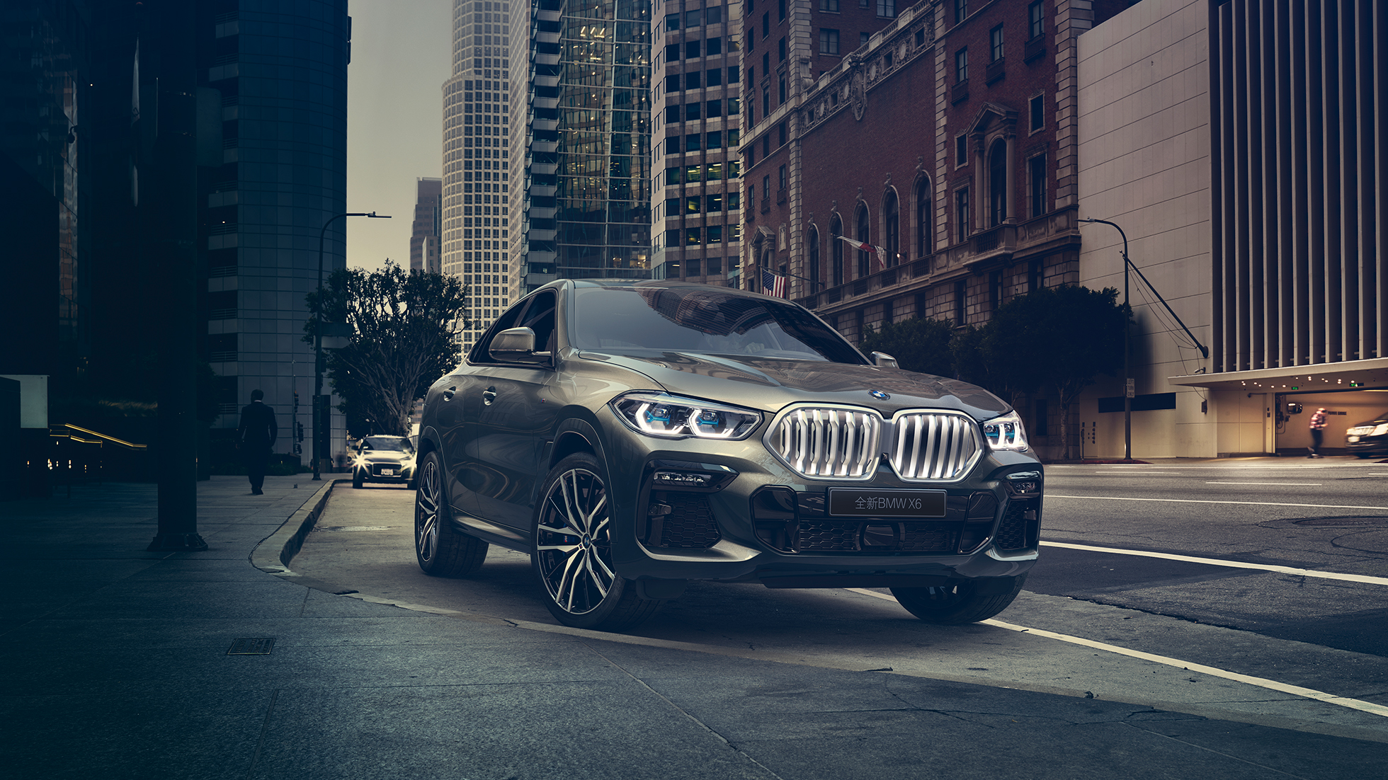 BMW X6 Adaptive M suspension Professional BMW X6 in three-quarter front perspective in front of an urban setting.