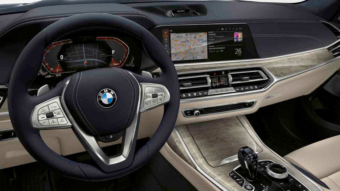 Adaptive 2-Axle Air Suspension BMW X7 driving in side perspective in front of rural background